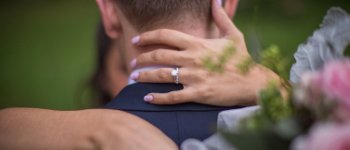 couple embracing showing engagement ring on woman's hand